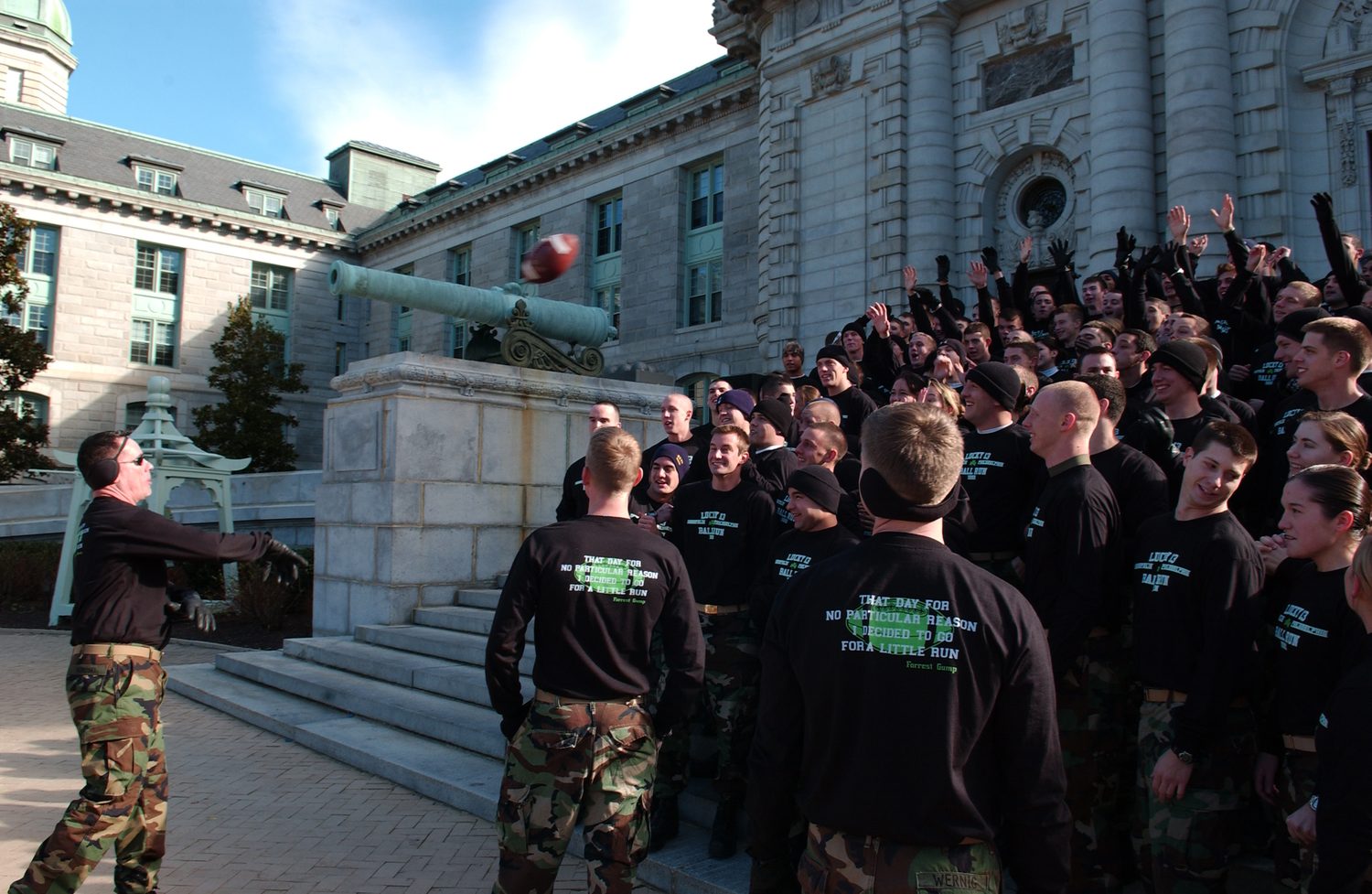 Midshipmen gather and toss a football for the Lucky 13 Ball Run pep event at the U.S. Naval Academy.
