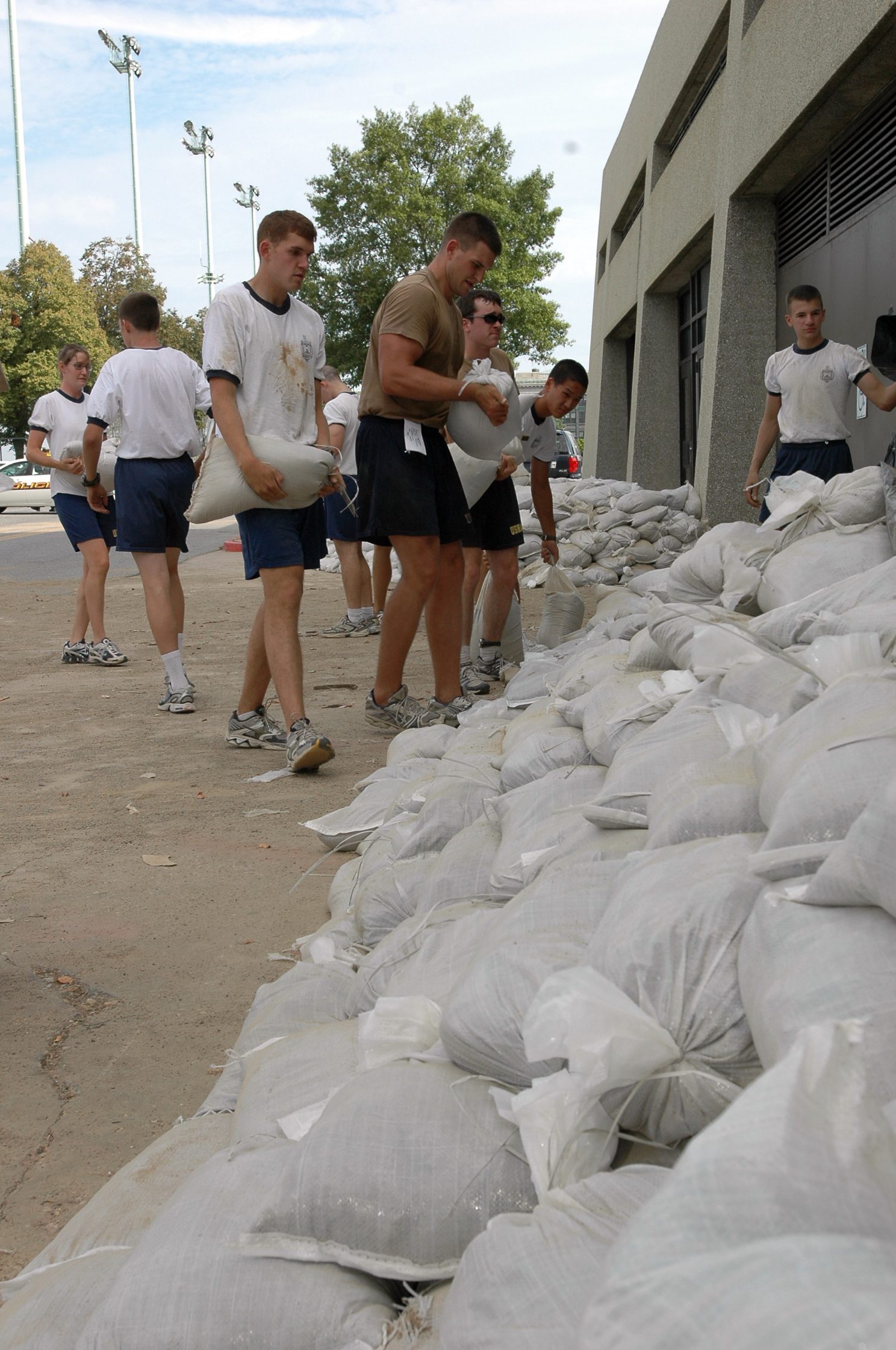 Midshipmen in formation preparing the Naval Academy grounds for an incoming storm.